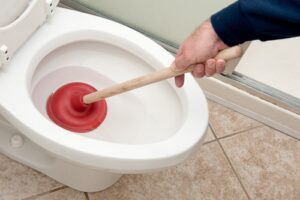 Plumber uncloging toilet
